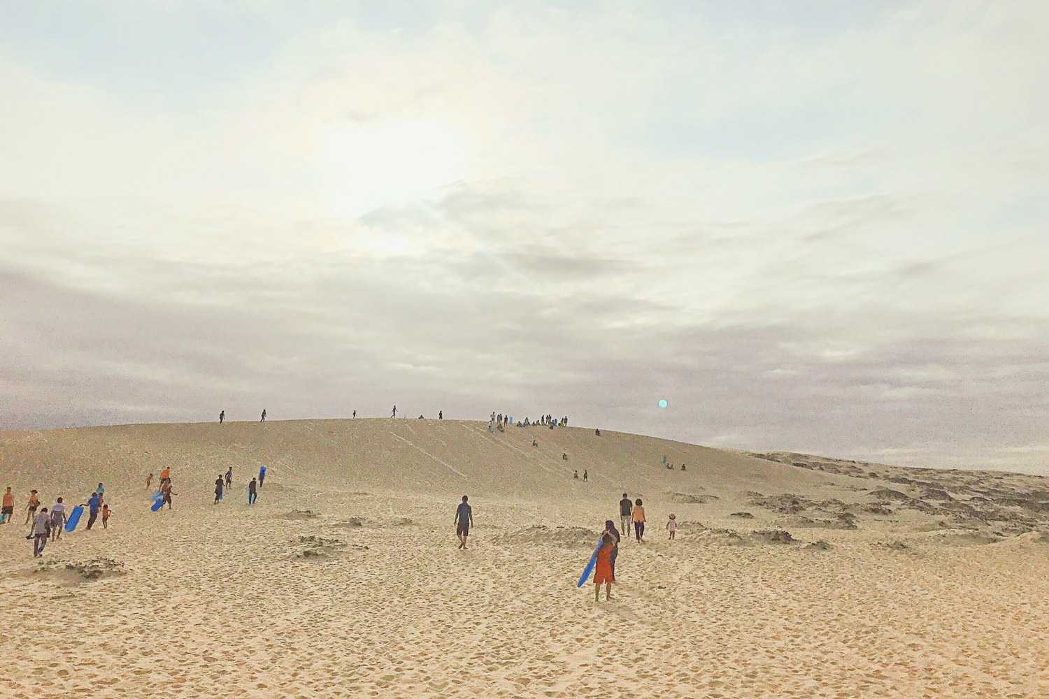 Khách du lịch và người dân đến đồi cát Quang Phú để ngắm cảnh và trượt cát.